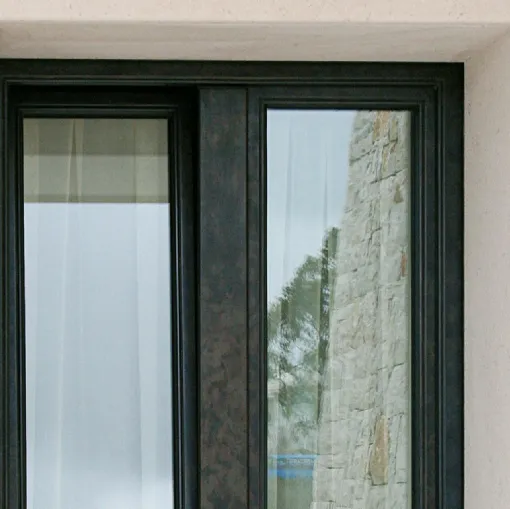 Finestra ad anta battente caratterizzata da anta e telaio in legno lamellare con rivestimento in bronzo saldato realizzato con una speciale lega di ottone Exter Bronze Classic di De Carlo