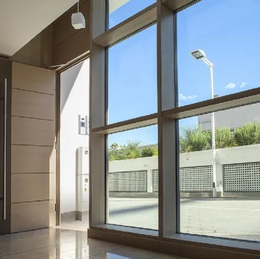 Serramenti fissi in legno e alluminio integrati con portoncino in legno Mix Porte di ingresso e D Wall di De Carlo